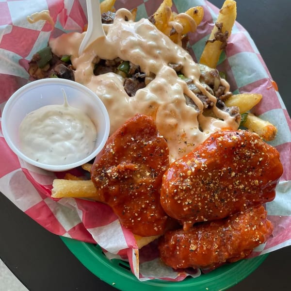 Vegan chili cheese fries with a side of ranch and three vegan buffalo wings.